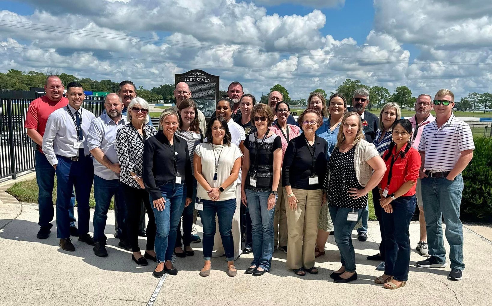 group photo of class members in front of racetrack