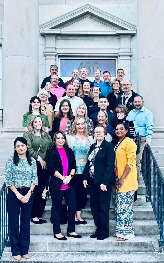 Group standing on steps in front of courthouse